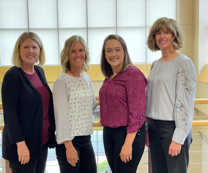 Photo of Mankato Clinic Hearing Care Center staff, smiling and standing by a railing